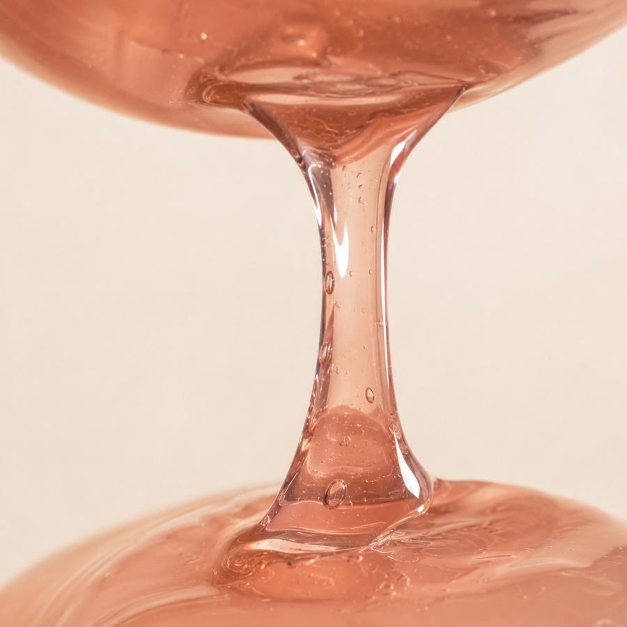 Textura translúcida del sérum Liptox cayendo en gotas densas color rosa
